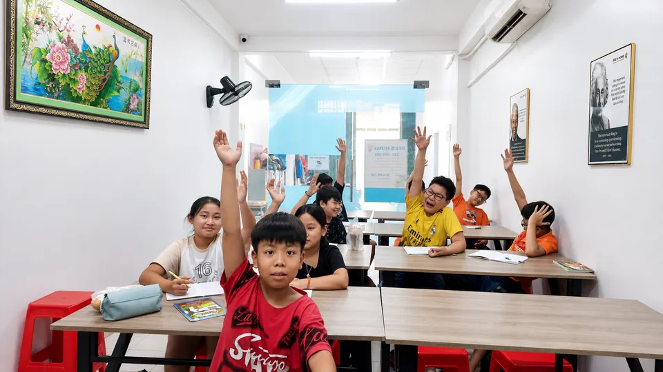 Học sinh sôi nổi giơ tay phát biểu trong lớp bán trú tại Bee's Home Academy — Dĩ An