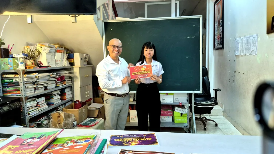Thầy Minh trao chứng nhận ghi nhận nỗ lực học tập cho học sinh tại Bee's Home Academy — Dĩ An